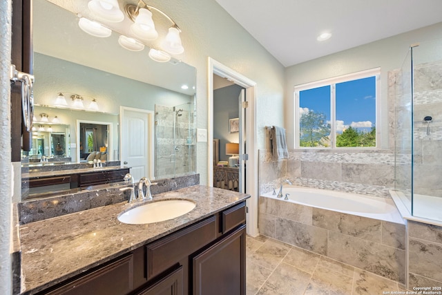 bathroom featuring a garden tub, vanity, and a stall shower