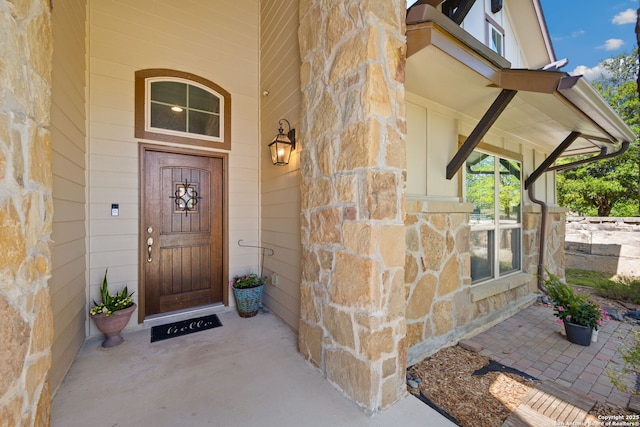 doorway to property with stone siding and a porch
