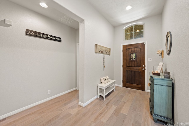entryway featuring baseboards, light wood-style floors, visible vents, and recessed lighting
