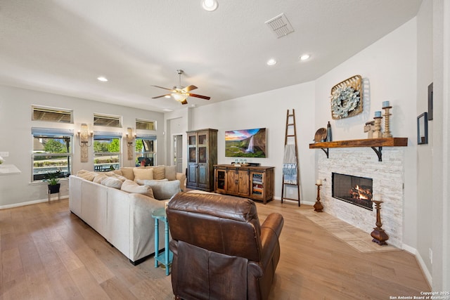 living area with recessed lighting, light wood finished floors, visible vents, a ceiling fan, and a fireplace