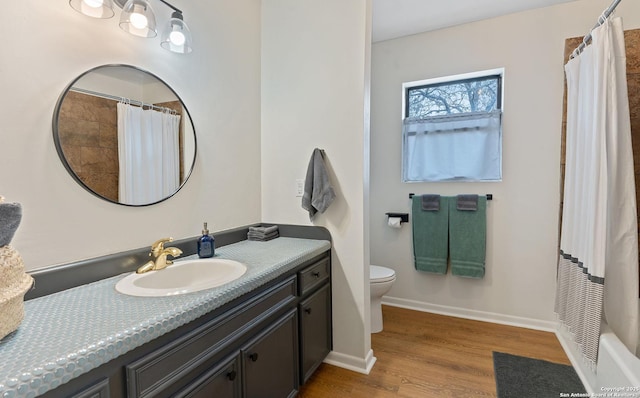 bathroom featuring wood finished floors, vanity, baseboards, toilet, and a shower with shower curtain