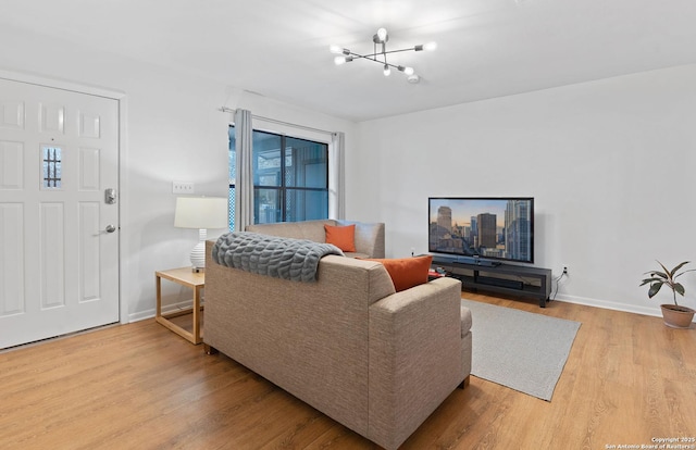 living room with an inviting chandelier, wood finished floors, and baseboards