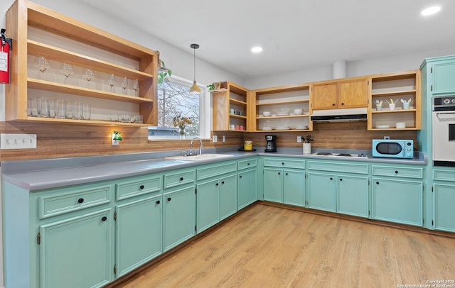 kitchen with open shelves, under cabinet range hood, white appliances, and a sink