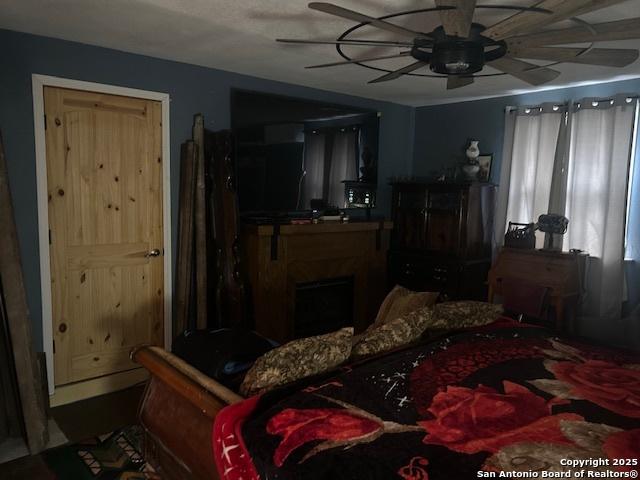 404 W Polk, Sabinal, TX 78881 - bedroom featuring ceiling fan and a fireplace