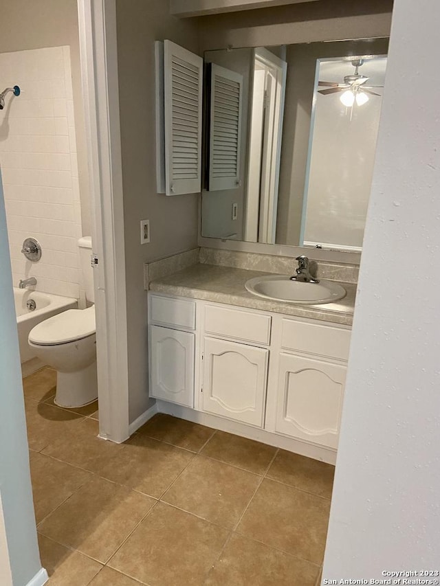 bathroom featuring tile patterned floors, a ceiling fan, vanity, toilet, and  shower combination