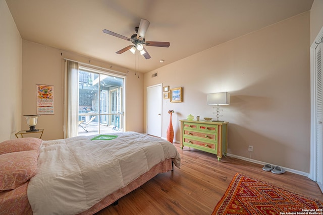 bedroom featuring baseboards, a ceiling fan, wood finished floors, and visible vents