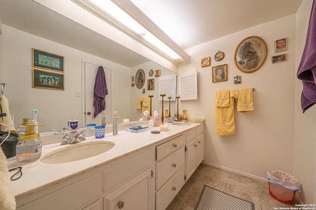 bathroom featuring double vanity, tile patterned floors, baseboards, and a sink