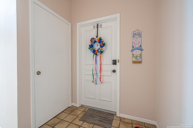 interior space featuring baseboards and light tile patterned flooring