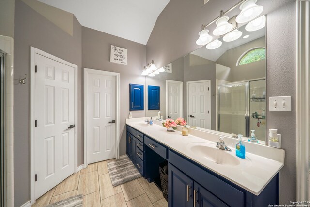 170 Pullman Rd, La Vernia, TX 78121 - bathroom with vaulted ceiling, a sink, double vanity, and a stall shower