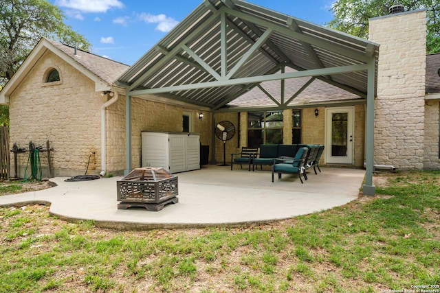 170 Pullman Rd, La Vernia, TX 78121 - back of property featuring stone siding, an outdoor living space with a fire pit, a patio, and a shingled roof