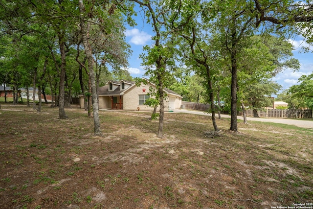170 Pullman Rd, La Vernia, TX 78121 - view of yard featuring a garage, concrete driveway, and fence