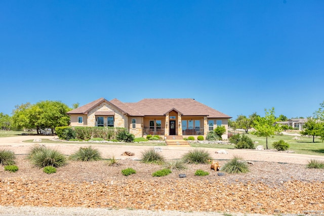 ranch-style home with stone siding and covered porch