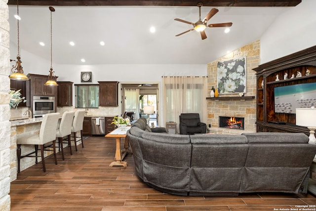living room featuring a ceiling fan, dark wood-style floors, high vaulted ceiling, and a fireplace
