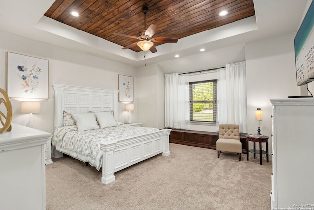 bedroom featuring wood ceiling, a tray ceiling, recessed lighting, and light colored carpet