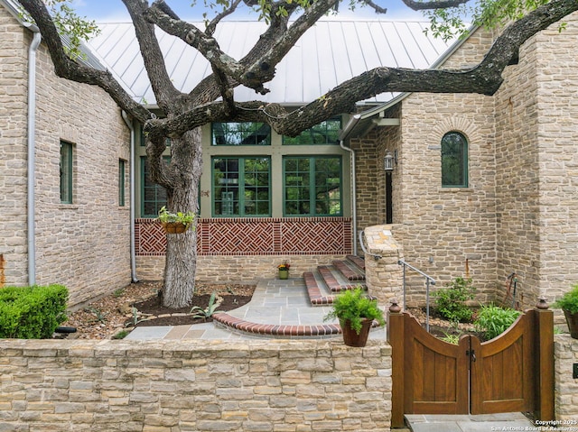 110 Turnberry Way, San Antonio, TX 78230 - property entrance featuring a standing seam roof, stone siding, metal roof, and a gate