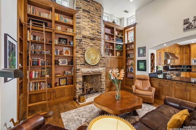 110 Turnberry Way, San Antonio, TX 78230 - living area featuring wood finished floors, healthy amount of natural light, a fireplace, a high ceiling, and built in shelves