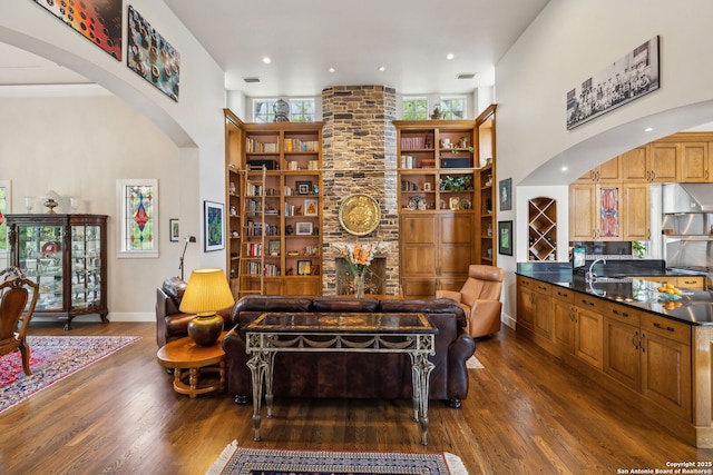 110 Turnberry Way, San Antonio, TX 78230 - living area featuring arched walkways, dark wood-style flooring, a towering ceiling, and baseboards