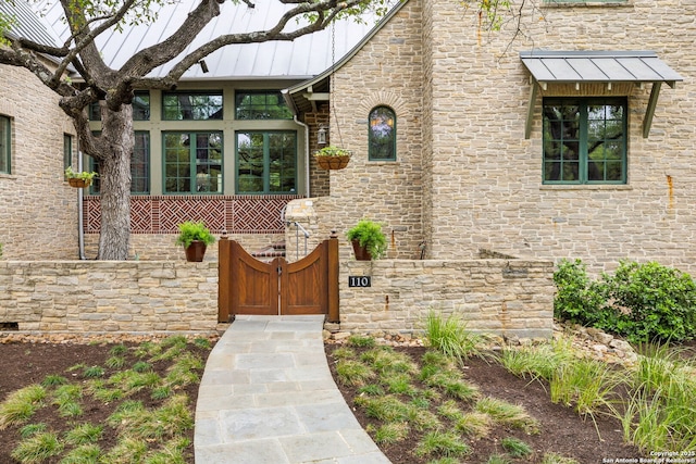 110 Turnberry Way, San Antonio, TX 78230 - entrance to property featuring stone siding, a standing seam roof, a gate, and metal roof