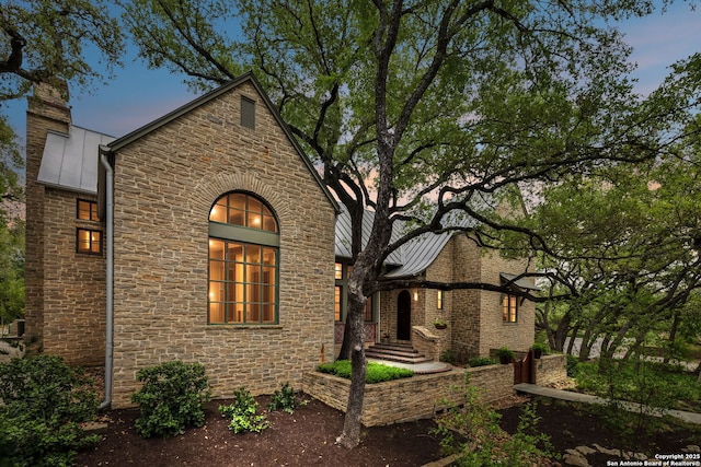 110 Turnberry Way, San Antonio, TX 78230 - view of front of property featuring stone siding, a standing seam roof, a chimney, and metal roof