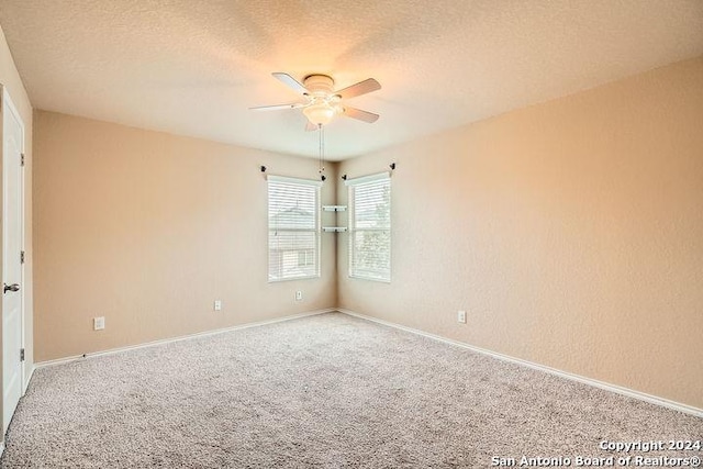 carpeted empty room featuring baseboards, a ceiling fan, and a textured ceiling