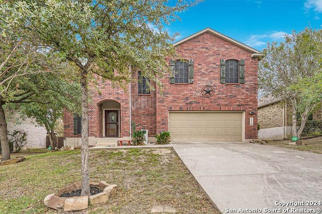 traditional-style home with a front lawn, brick siding, driveway, and a garage
