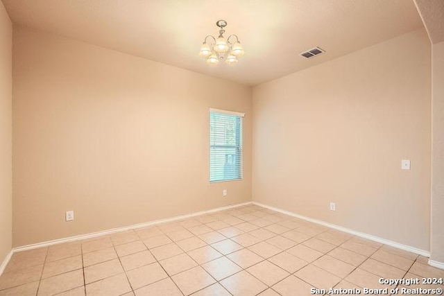 empty room with arched walkways, light tile patterned flooring, baseboards, visible vents, and a chandelier