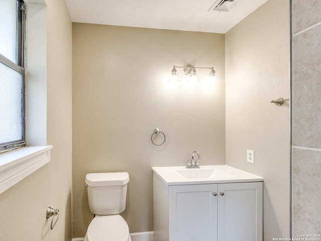 half bathroom with plenty of natural light, visible vents, toilet, and vanity