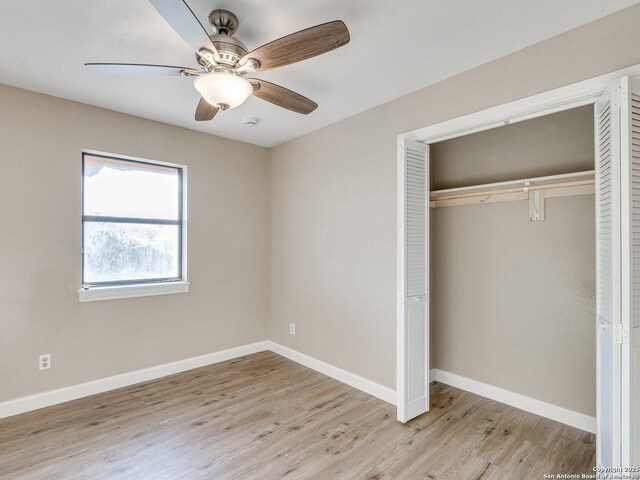 unfurnished bedroom featuring light wood-style floors, a closet, a ceiling fan, and baseboards