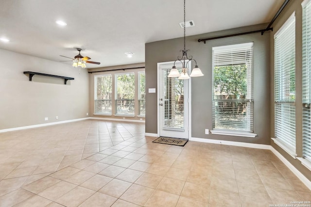interior space featuring baseboards, ceiling fan with notable chandelier, visible vents, and light tile patterned floors