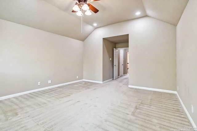 spare room with baseboards, lofted ceiling, a ceiling fan, and light colored carpet