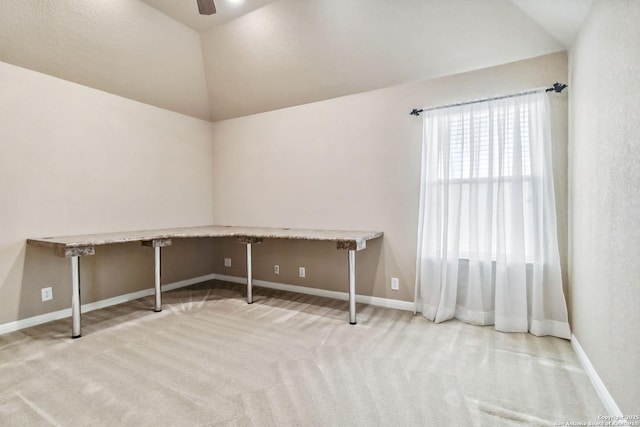 unfurnished office featuring lofted ceiling, carpet floors, and baseboards