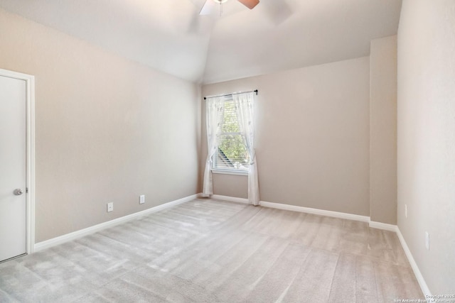 carpeted empty room with lofted ceiling, baseboards, and ceiling fan