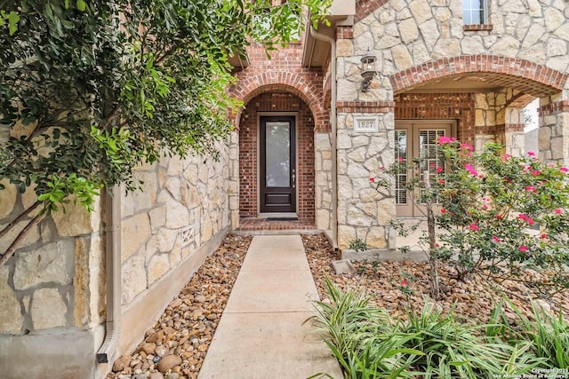 property entrance featuring brick siding and stone siding