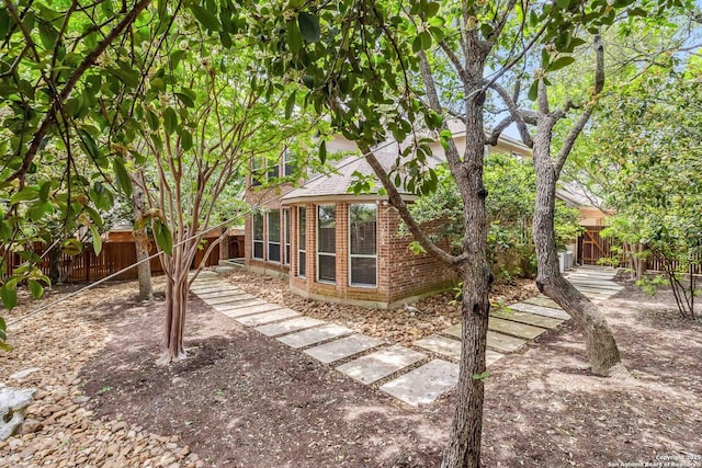 exterior space featuring a fenced backyard and brick siding