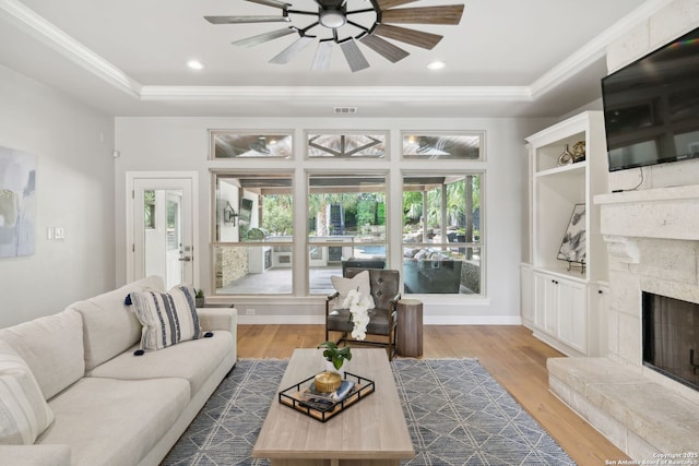 living area featuring ornamental molding, a tray ceiling, dark wood-type flooring, and ceiling fan