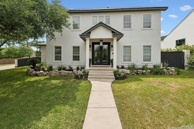 view of front of house featuring fence, a front yard, and stucco siding