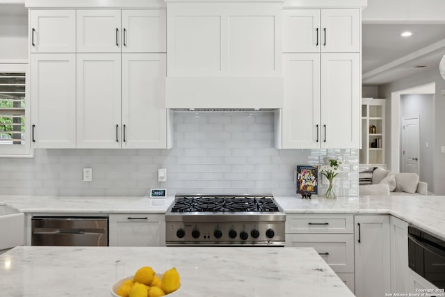 kitchen with stove, backsplash, dishwasher, and white cabinetry