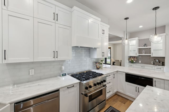 kitchen with a warming drawer, custom exhaust hood, stainless steel appliances, and white cabinetry