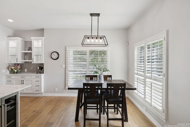 dining area with recessed lighting, baseboards, beverage cooler, and light wood-type flooring