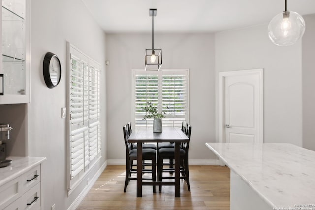 dining area with light wood-style flooring and baseboards