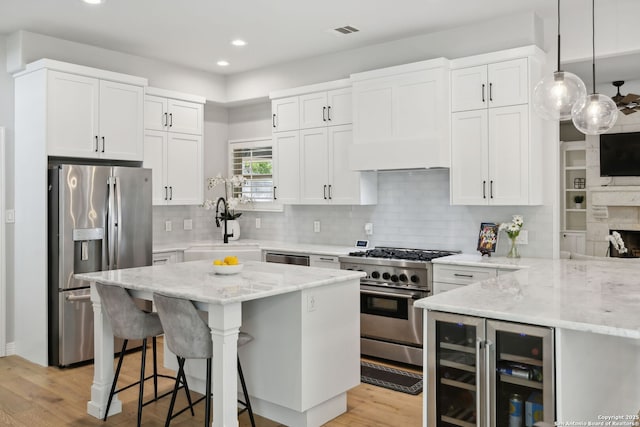 kitchen featuring a sink, stainless steel appliances, light stone countertops, visible vents, and recessed lighting
