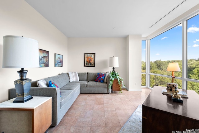 living area featuring baseboards and floor to ceiling windows