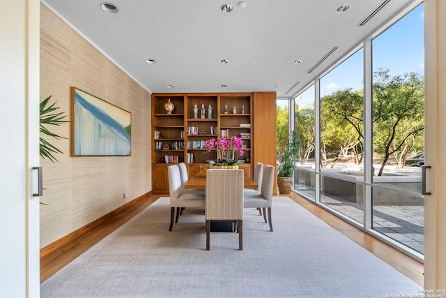 dining area with recessed lighting, wood finished floors, and a wall of windows