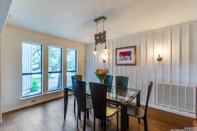 dining space featuring baseboards, dark wood-style flooring, a textured ceiling, and visible vents