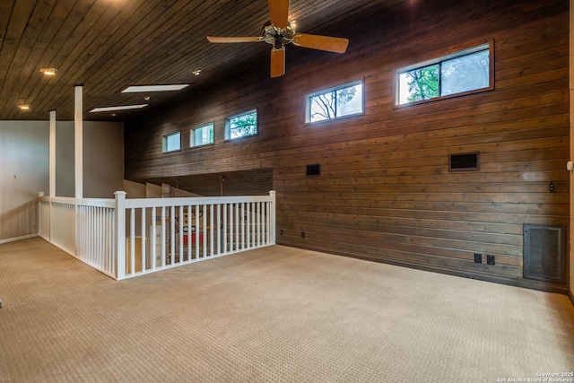 empty room featuring recessed lighting, wooden walls, a ceiling fan, wooden ceiling, and carpet flooring