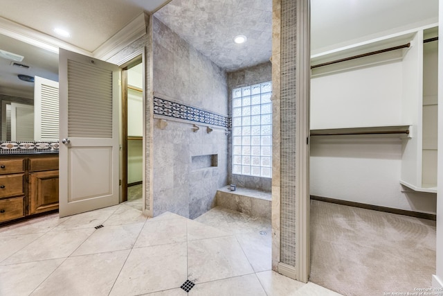full bathroom with tile patterned flooring, baseboards, vanity, and a tiled fireplace