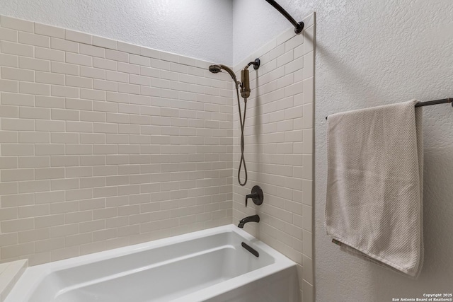 full bathroom with a textured wall and shower / tub combination