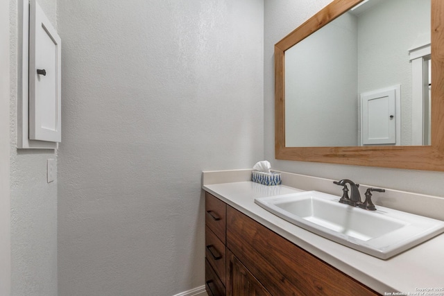 bathroom featuring a textured wall and vanity