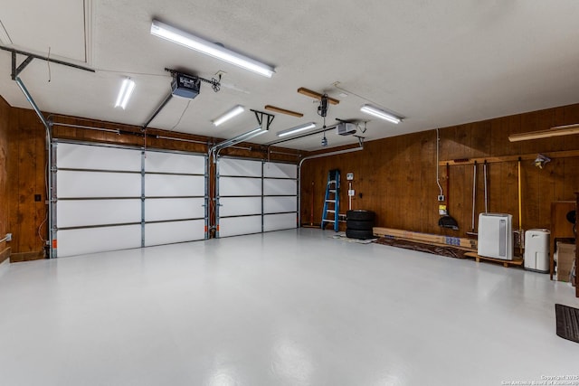 garage featuring wooden walls and a garage door opener
