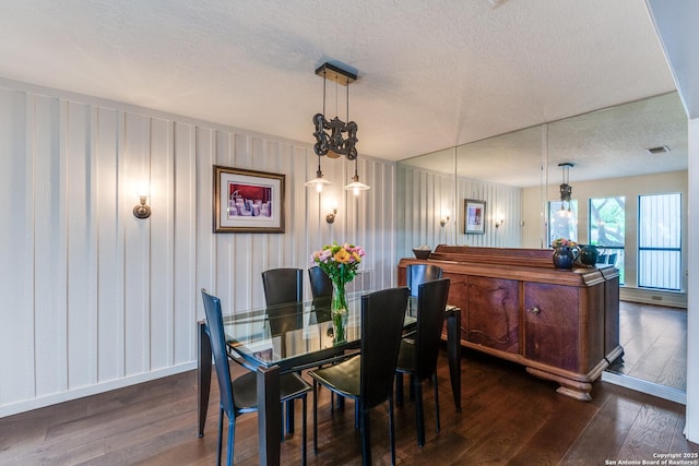 dining area featuring visible vents, baseboards, dark wood-style floors, and a textured ceiling